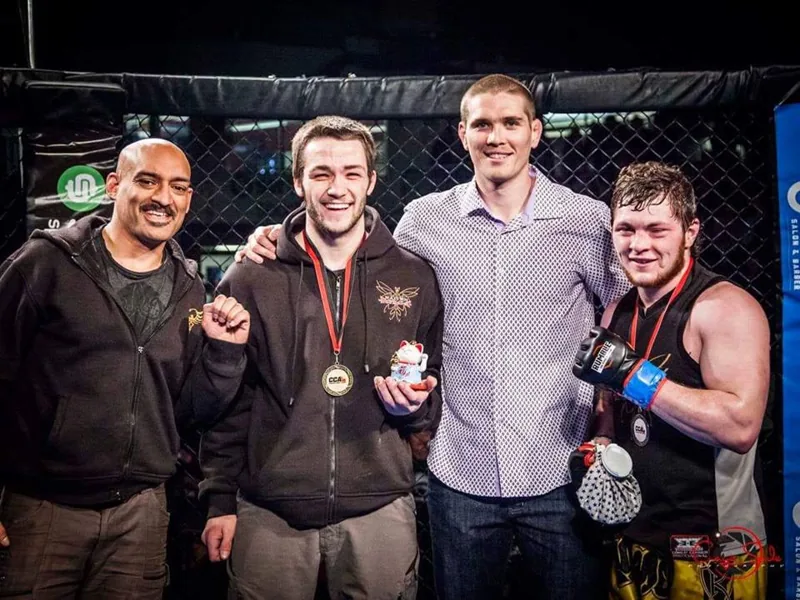 Coaches and fighters cage side after a win