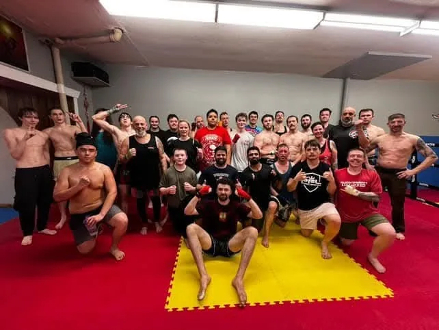 A busy kickboxing class training together on the mats