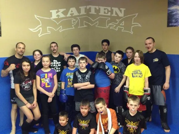Kids team photo under the Kaiten wall